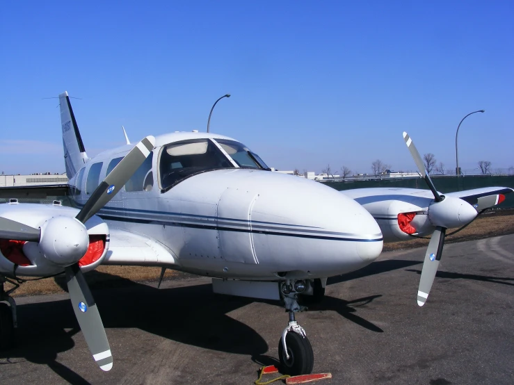 small airplane sits in an airport next to another plane