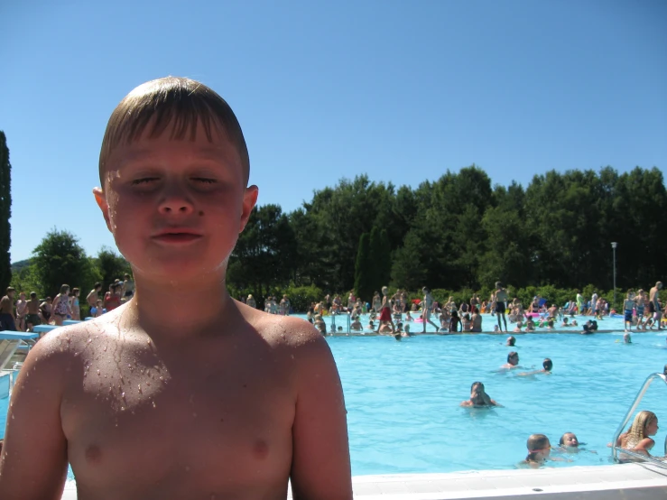a boy with  by a pool in the summer
