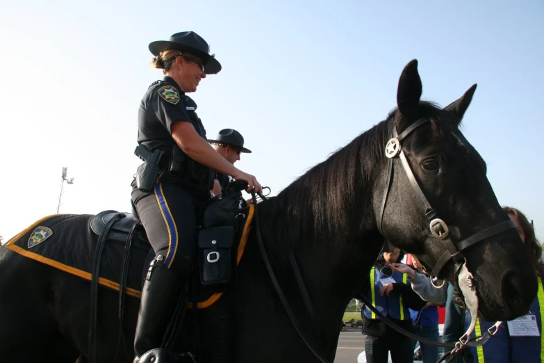 two mounted police officers riding horses with others around