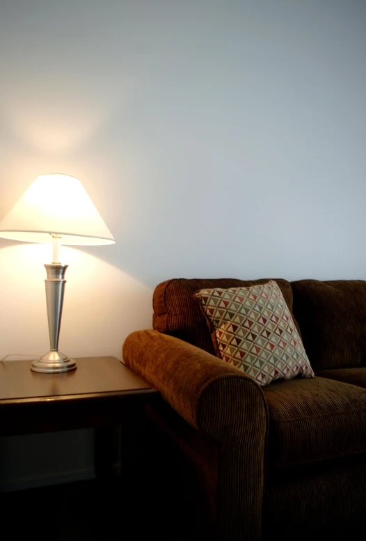 the couch next to the lamp is clean and ready to be used