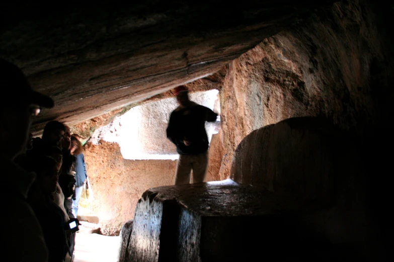 group of people looking out from a cave at night