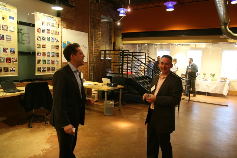 two men in business suits are talking with each other