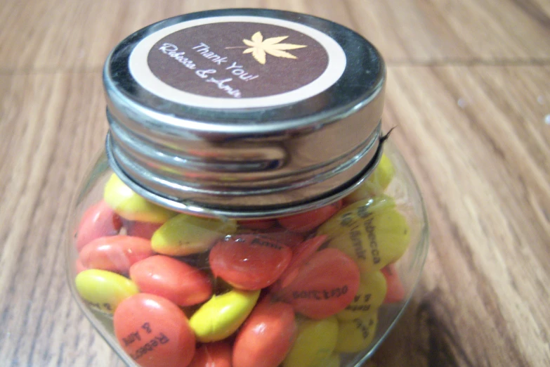 a glass jar filled with candy corn, and oranges