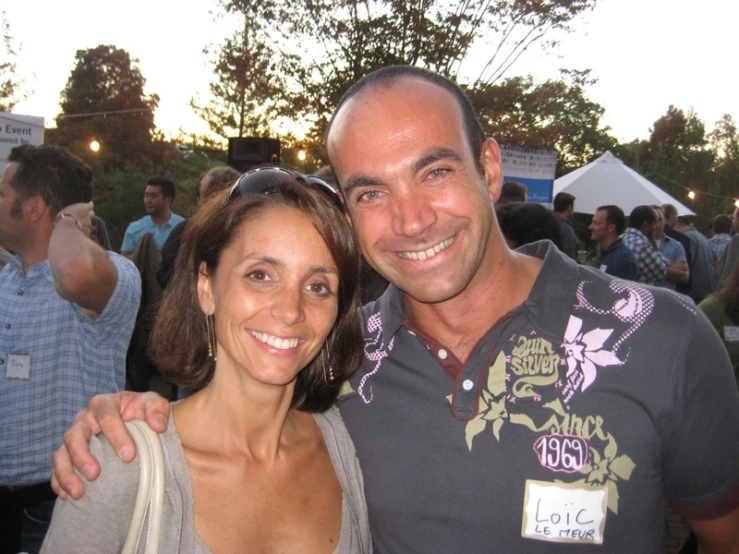 a man and woman posing for a picture while they are smiling