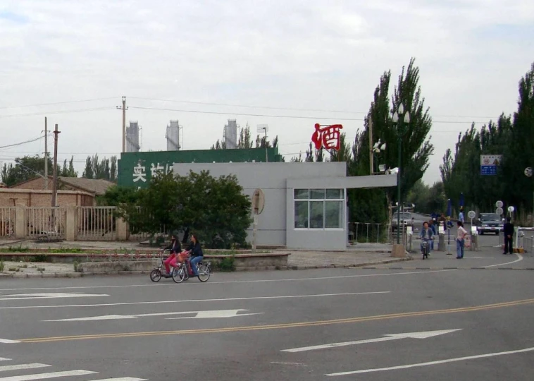 three people riding bikes down a city street