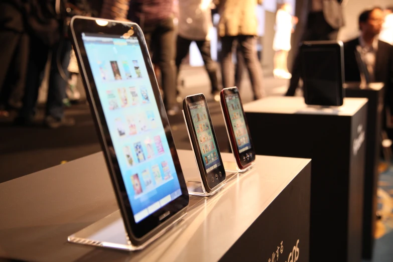 four smart phones sitting next to each other on display