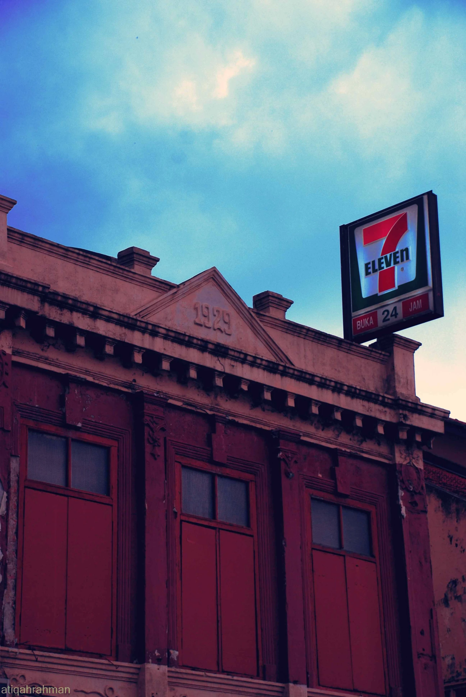 a very tall building with red doors and a sign on it