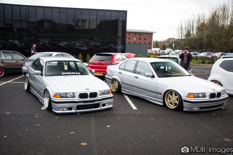 white cars parked in a parking lot next to another car