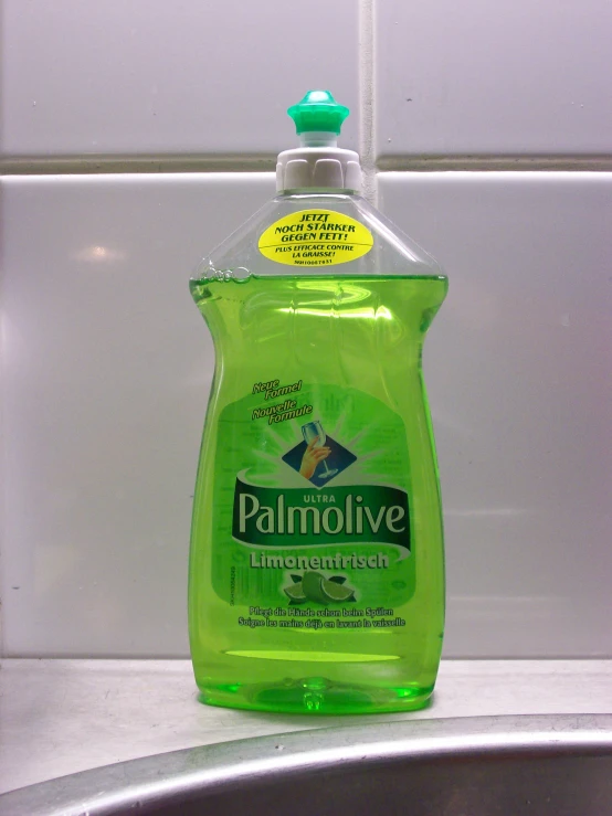 a dishwasher bottle sitting on the sink counter next to the faucet