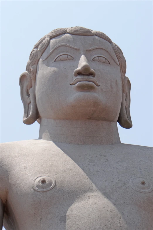 a statue of a girl with no  sitting next to a sky background