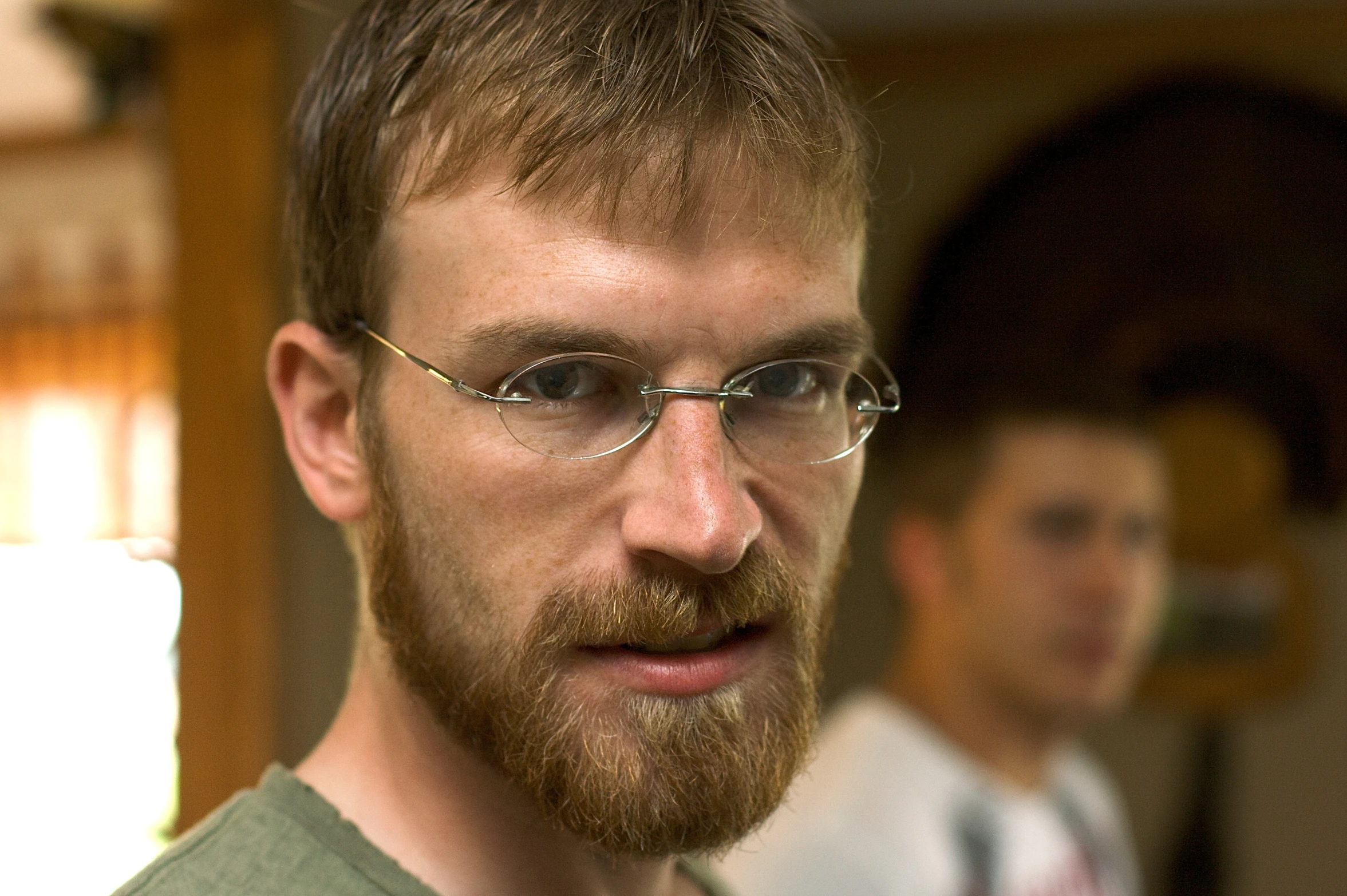 two men wearing glasses and green shirts