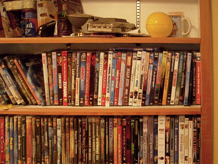 a wooden book shelf with a number of dvd's on it