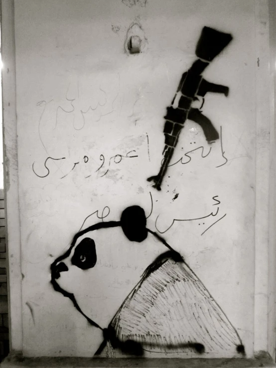 a panda face and a hat with graffiti on the wall