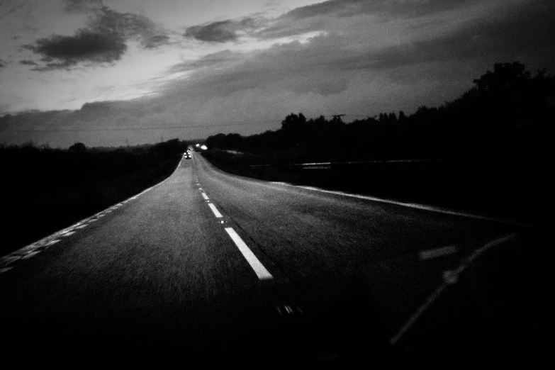 an empty highway at night with cars passing