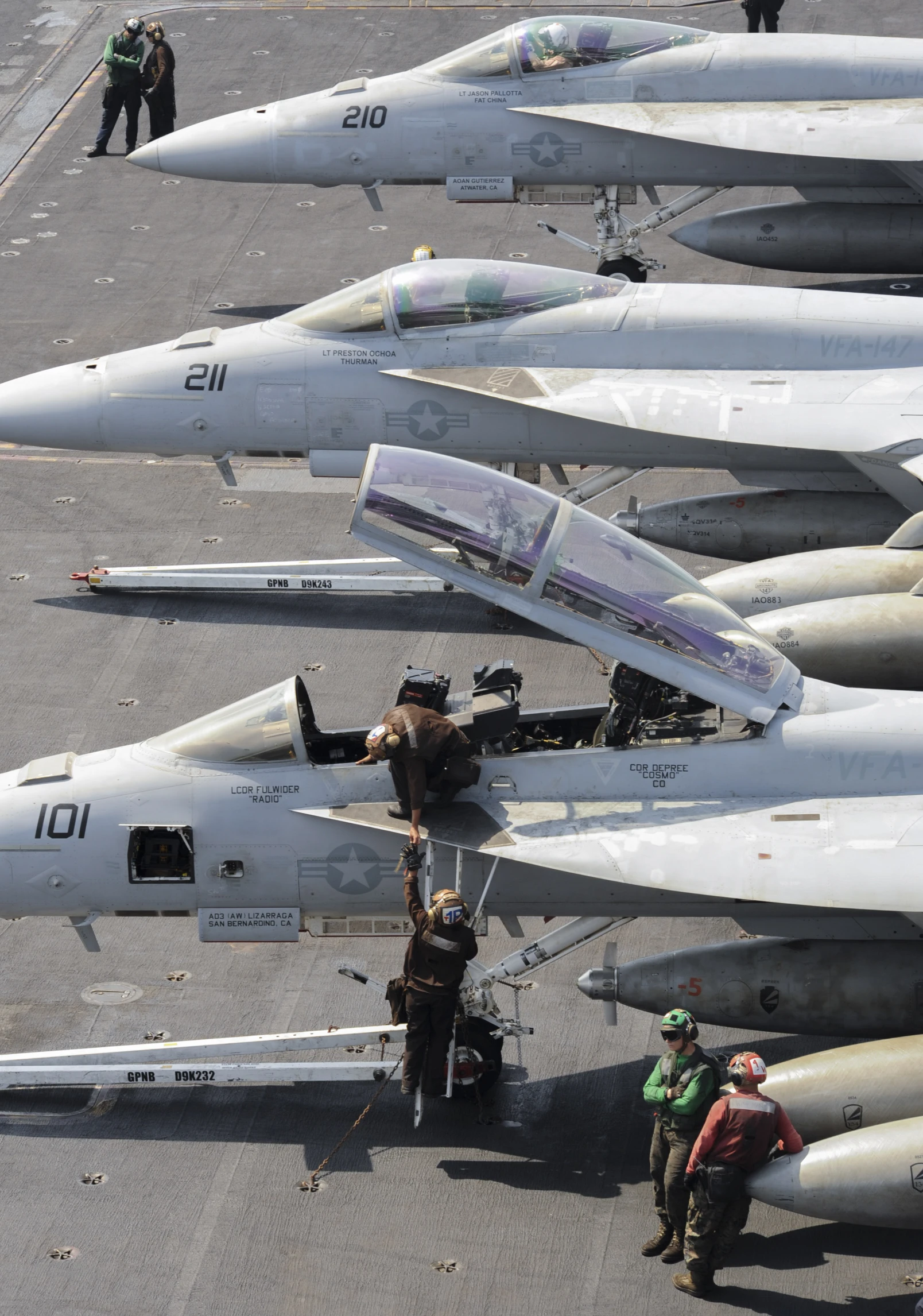 a large group of people standing around fighter jets