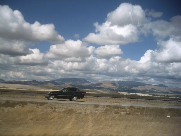 a truck driving on the road next to a field