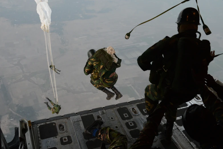 two military personnel are performing aerial stunts in the air