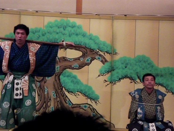 an oriental man and another asian woman perform on stage