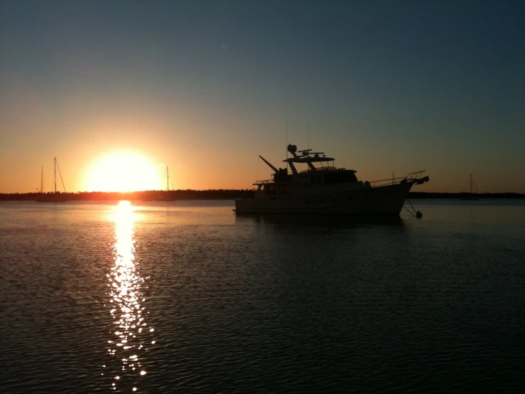 a boat in a large body of water during a sunset