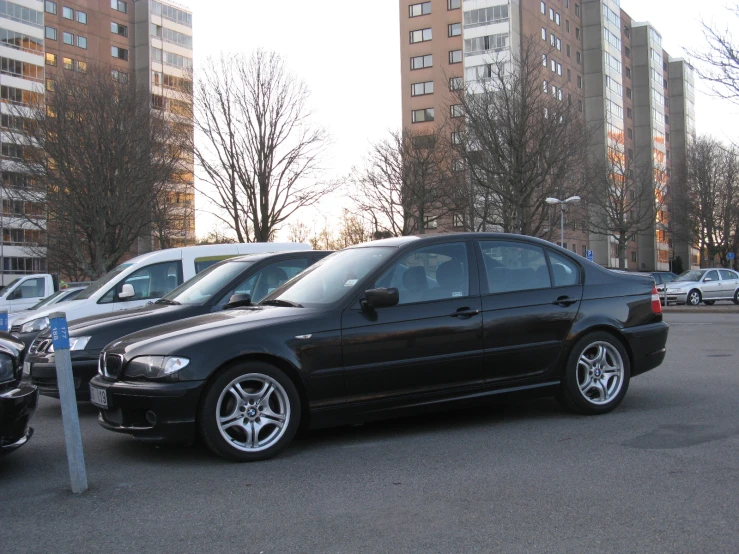 several parked cars sit in a parking lot