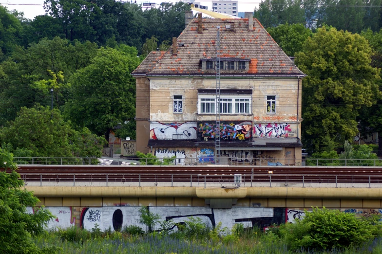 a house with graffiti on the roof in the forest
