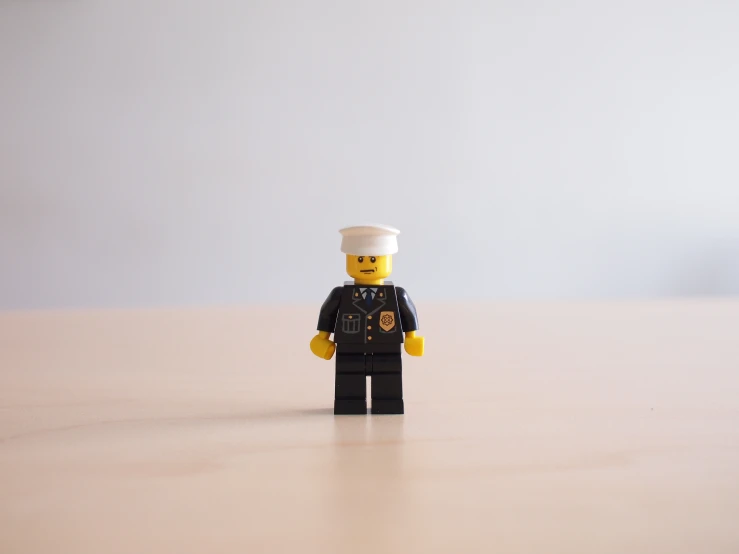 a lego soldier standing on the table, holding a paper