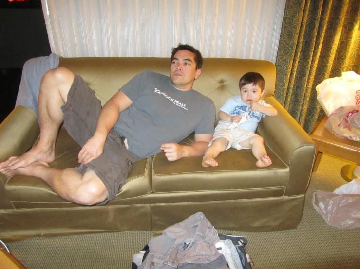 a man and a baby sit on a couch