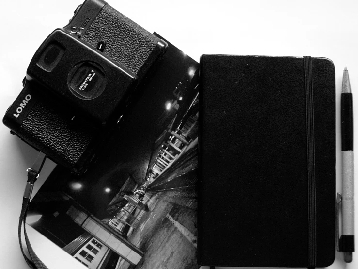 a camera and a notebook open with an image of a city
