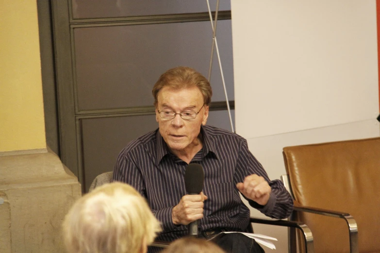 a man holds a microphone and speaks at a seminar