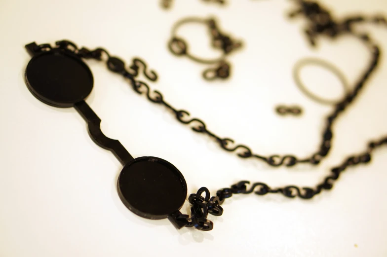 a necklace is attached to a black hook