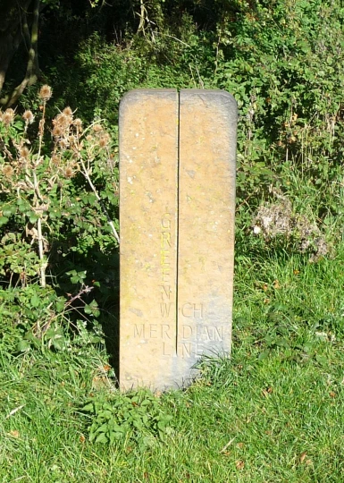 an old tombstone sitting in some grass