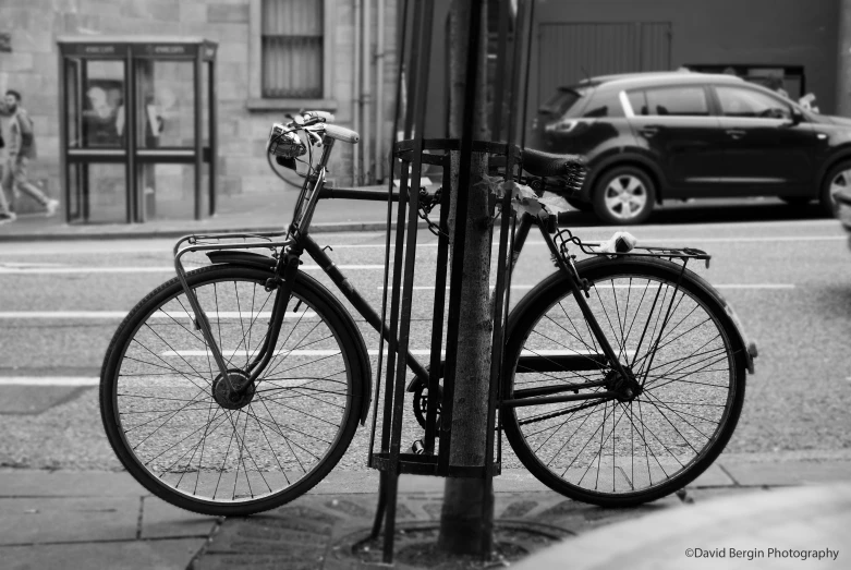 the bicycle is leaning against the traffic pole