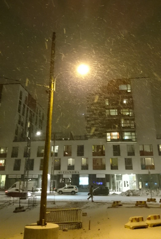 city buildings at night with snow falling around
