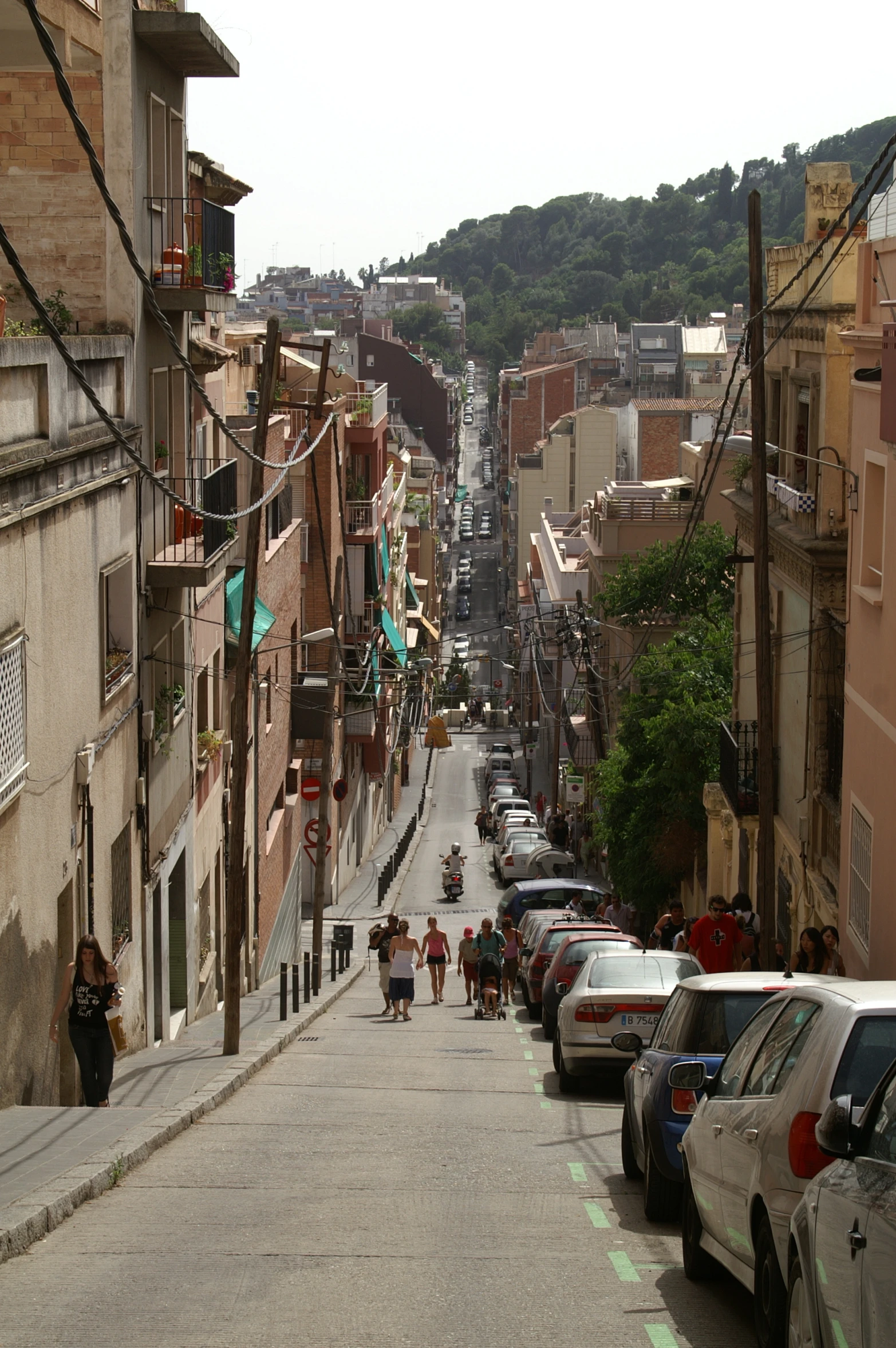 the people walk down the city street by their cars