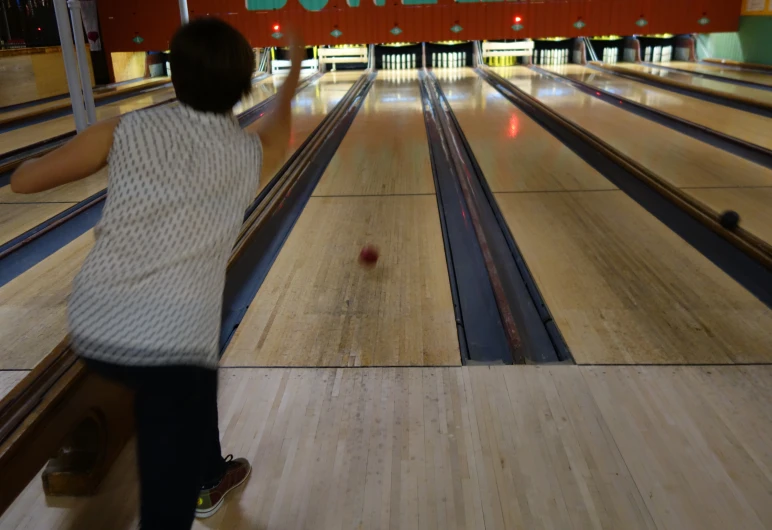 there is a young lady standing at the bowling alley