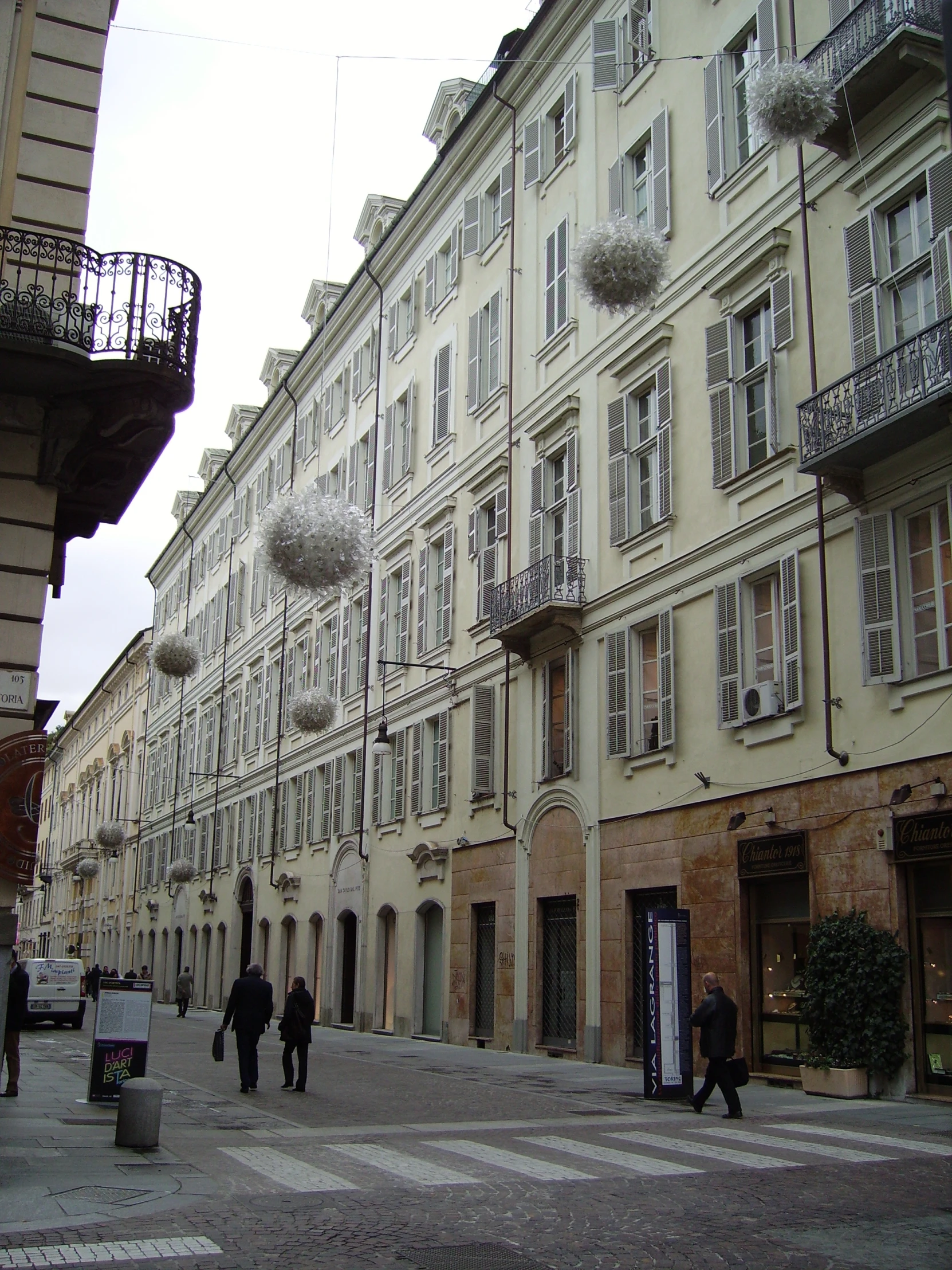 people walking along a cobblestone city street