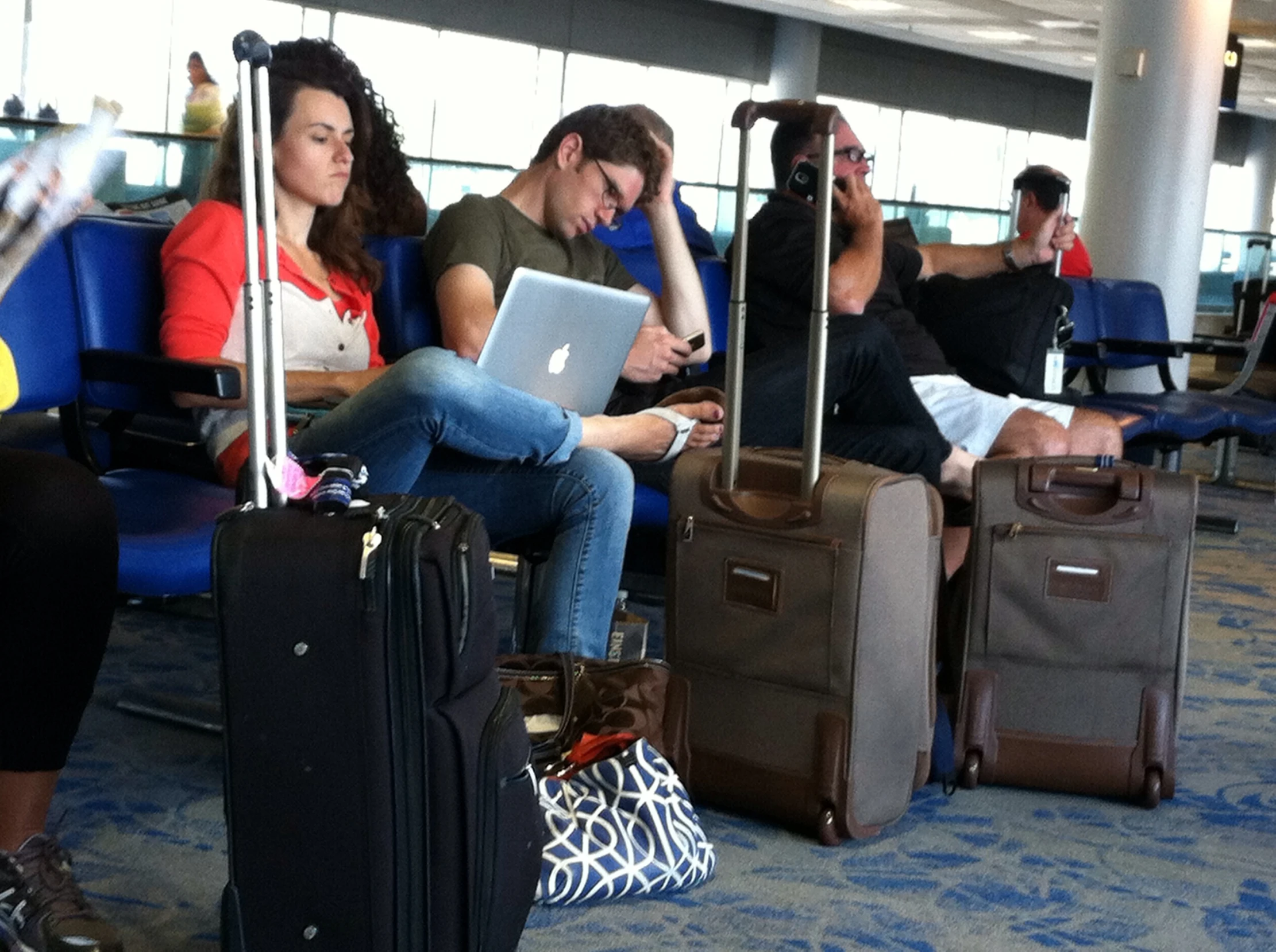 three people are looking at their computers while waiting