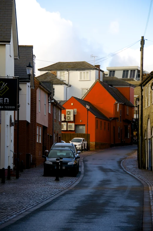 cars are parked along the street as the sun goes down