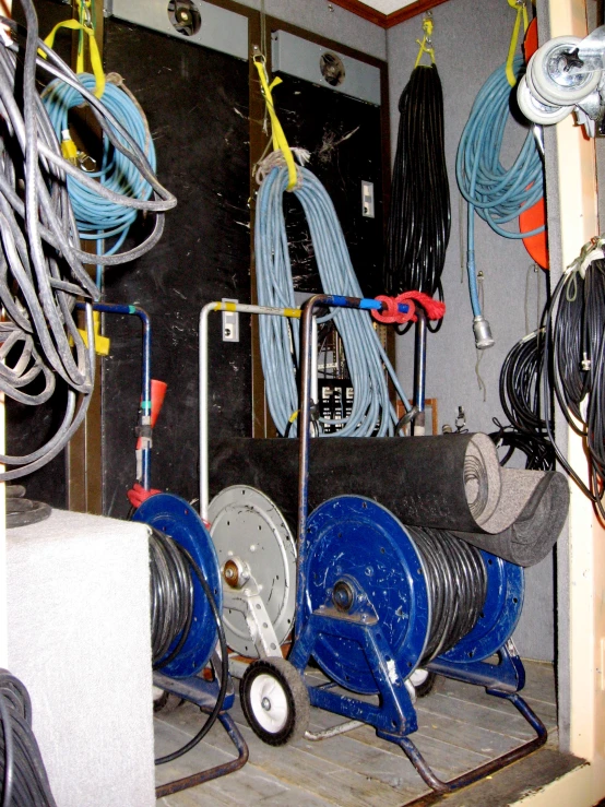 two large blue hoses in a garage surrounded by wire and wires