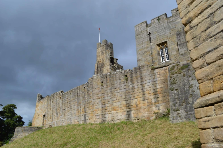 a castle tower sits between two large walls