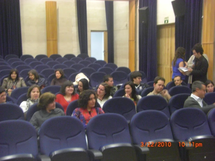 a large room with several people sitting on chairs in it