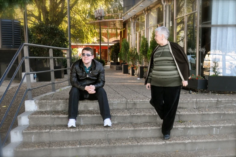 a couple of women sitting on top of cement steps