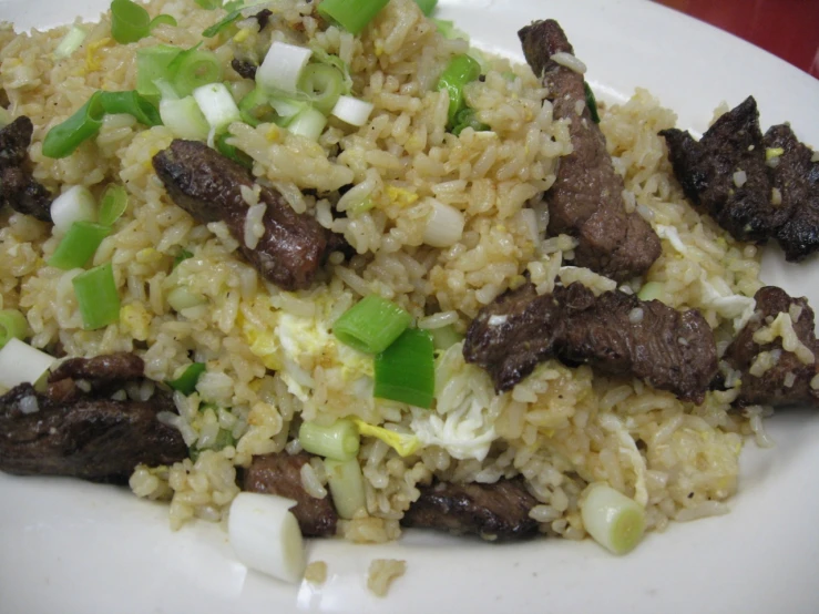 meat, onions, and celery on a plate with rice