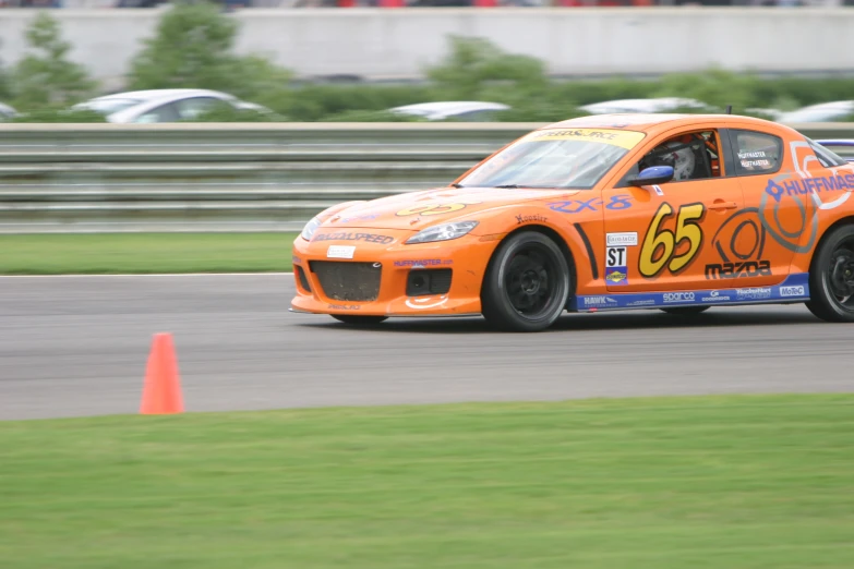 an orange car with numbers drives along the track