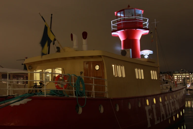 an illuminated lighthouse and boat on the water