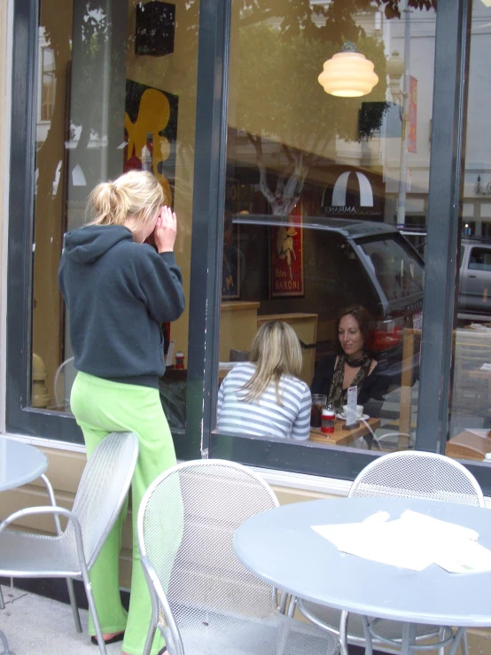 a woman is sitting in a restaurant talking on her phone