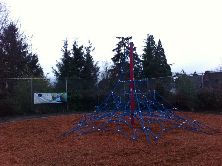 a colorful outdoor play structure with trees in the background