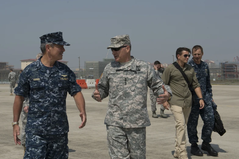 several military men are walking in a line