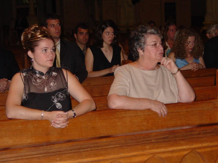 a woman in a church sits next to a lady, while people look on