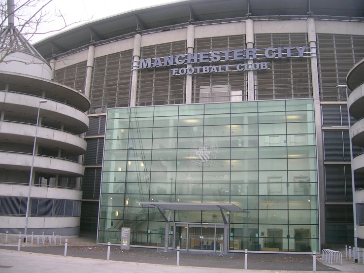 a glass building with a fence next to it